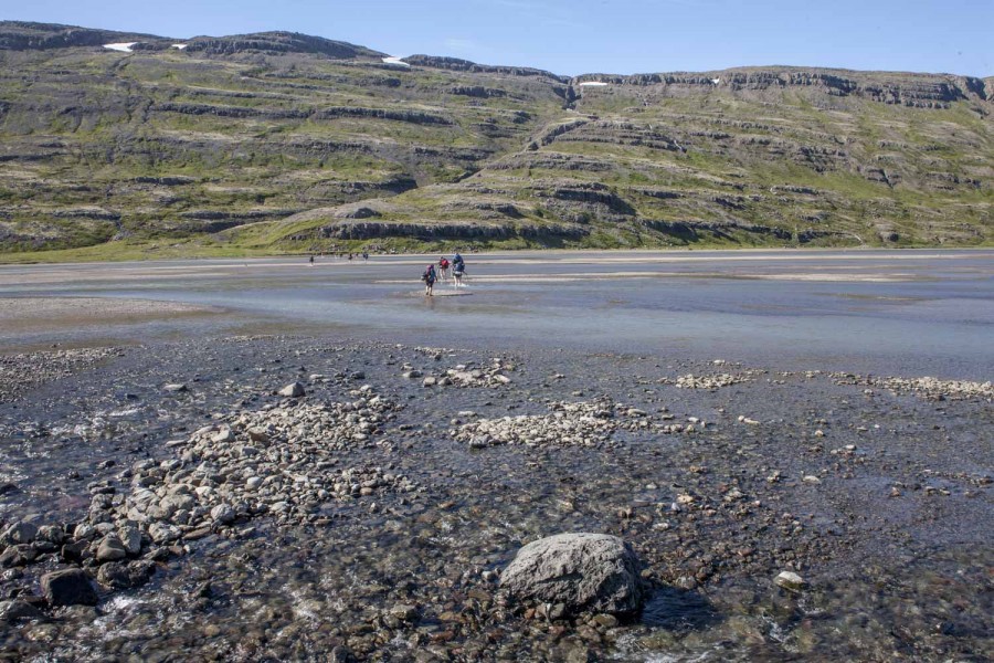 Islandia grupa przechodzaca przez fjord podczas odpływu